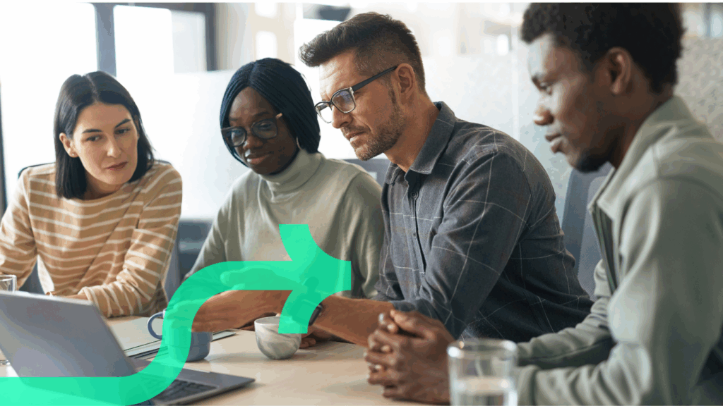 Team of diverse professionals collaborating around a laptop during a Discflow leadership workshop, discussing communication and leadership styles.